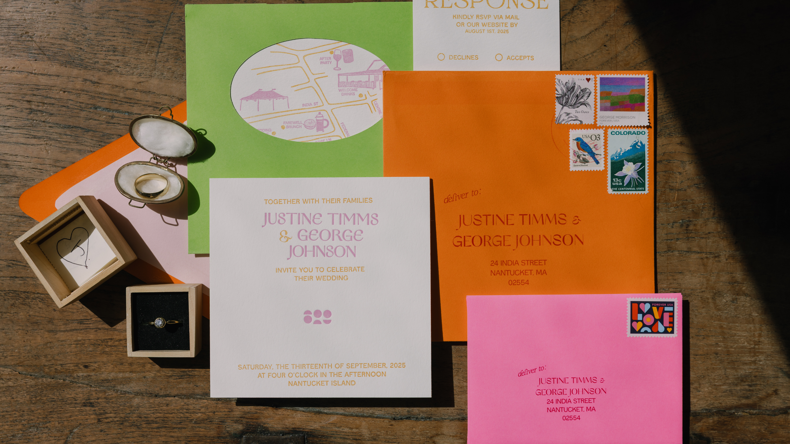 Collection of wedding invitations and stationery items on a wooden surface