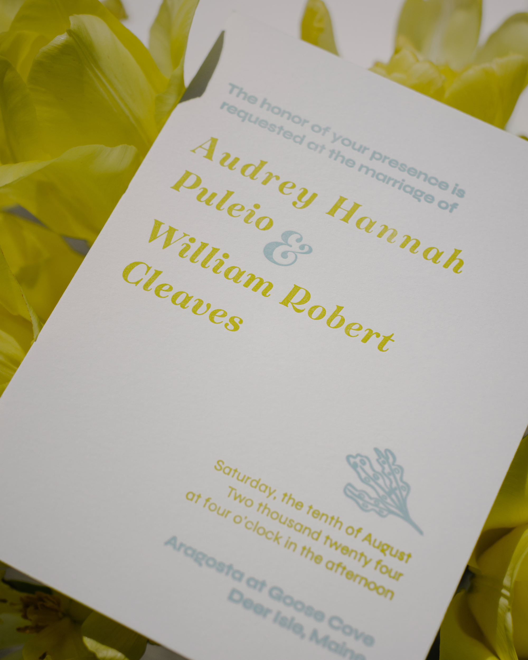 Wedding invitation card with green text on a white background, surrounded by yellow flowers.