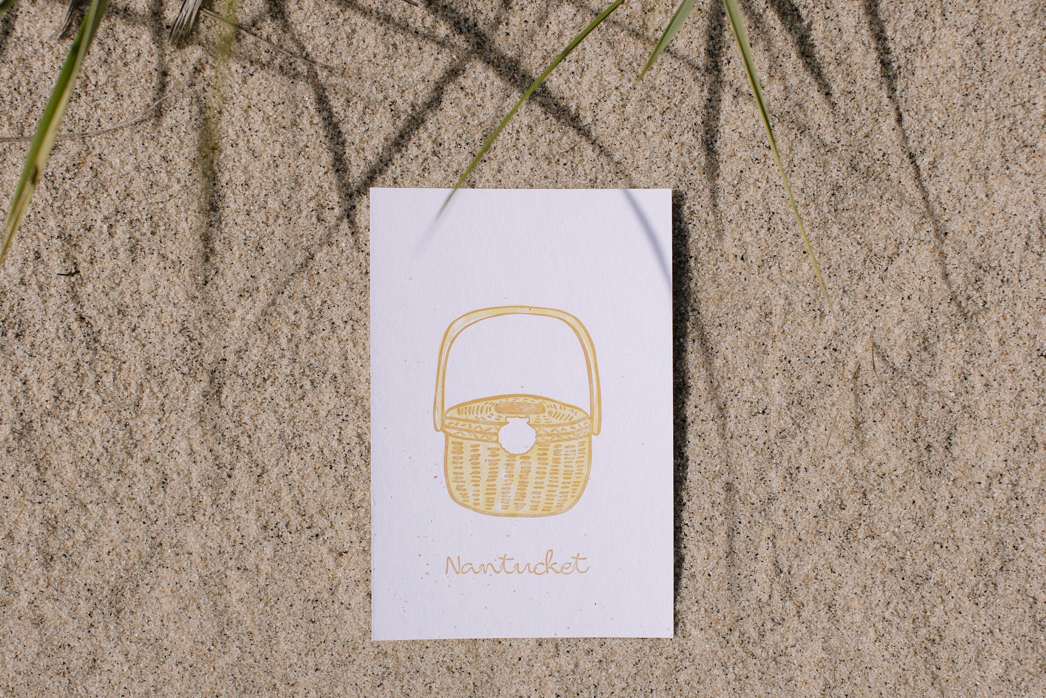 Card with a wicker basket design on sand