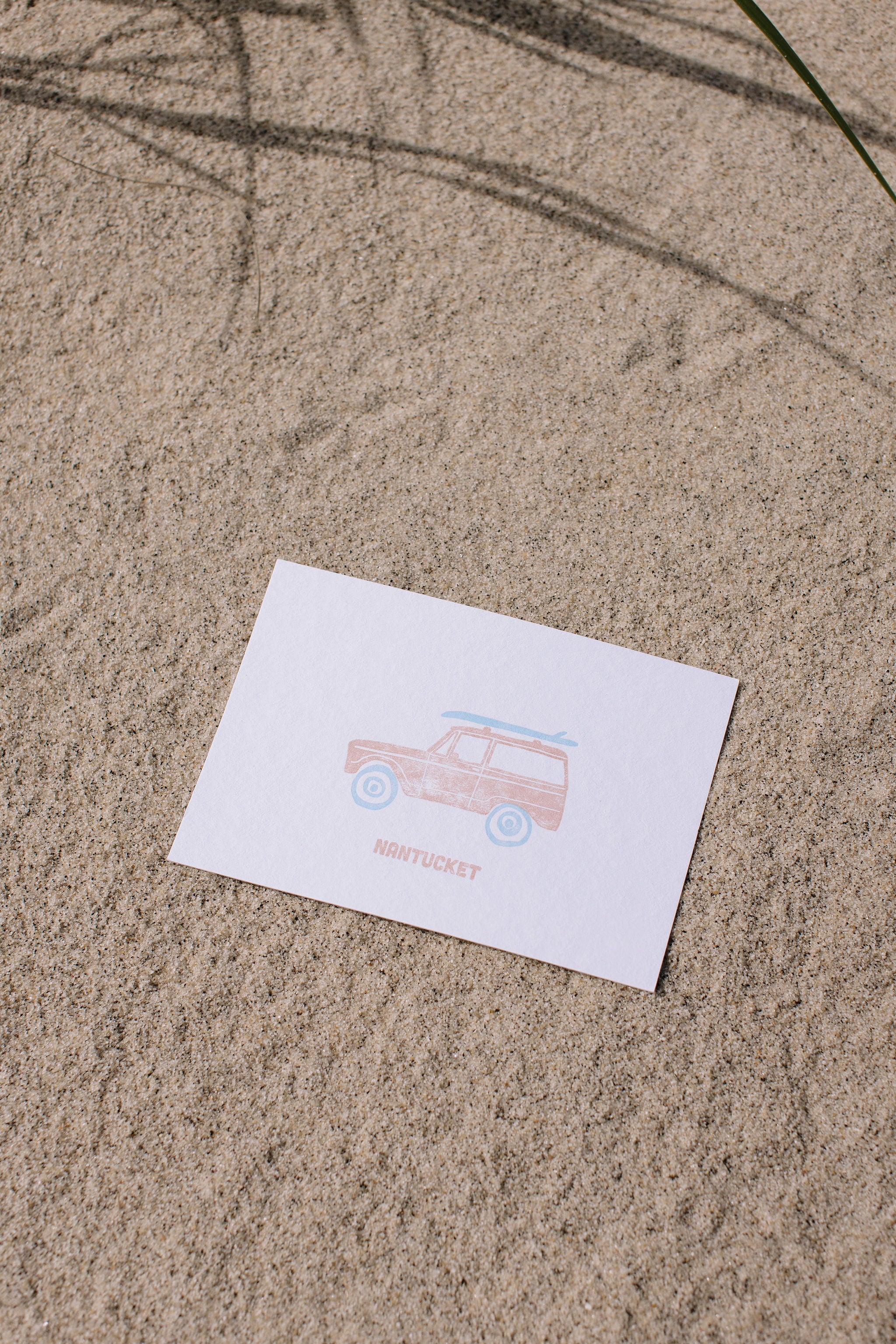 Postcard with an illustration of a Ford bronco with a surfboard on top and 'Nantucket' text on sand